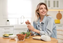 Žena u stolu, na kterém jsou mandle a salát.