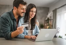 Žena a muž s platební kartou v ruce nakupující na internetu