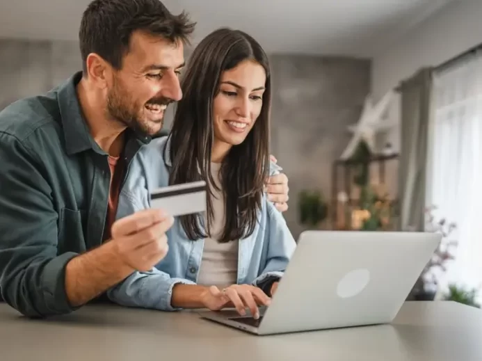 Žena a muž s platební kartou v ruce nakupující na internetu