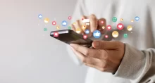 Osoba drží v ruce mobilní telefon