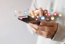 Osoba drží v ruce mobilní telefon