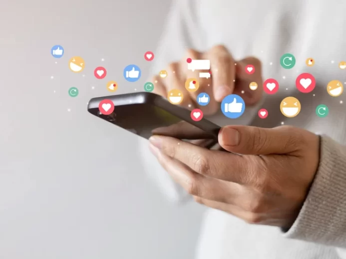 Osoba drží v ruce mobilní telefon