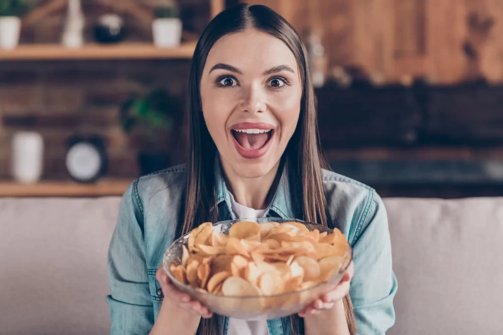 Shutterstock_1964840821 - Pravda24 Žena s mísou brambůrků