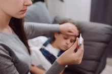 Žena měří teplotu dítěti