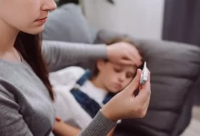 Žena měří teplotu dítěti