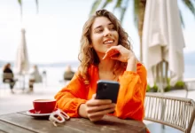 Žena přemýšlí s mobilním telefonem v ruce