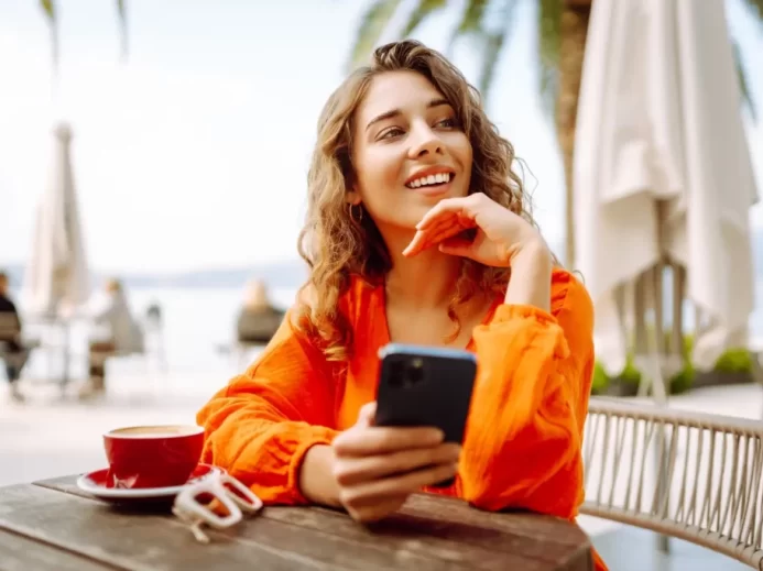 Žena přemýšlí s mobilním telefonem v ruce