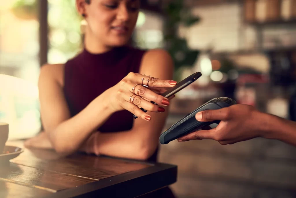 Shutterstock_2466962435 - Pravda24 Žena platí mobilním telefonem