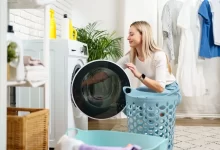 Žena vkládá prádlo do pračky