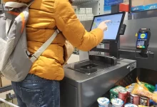 Žena platí u bezkontaktní pokladny