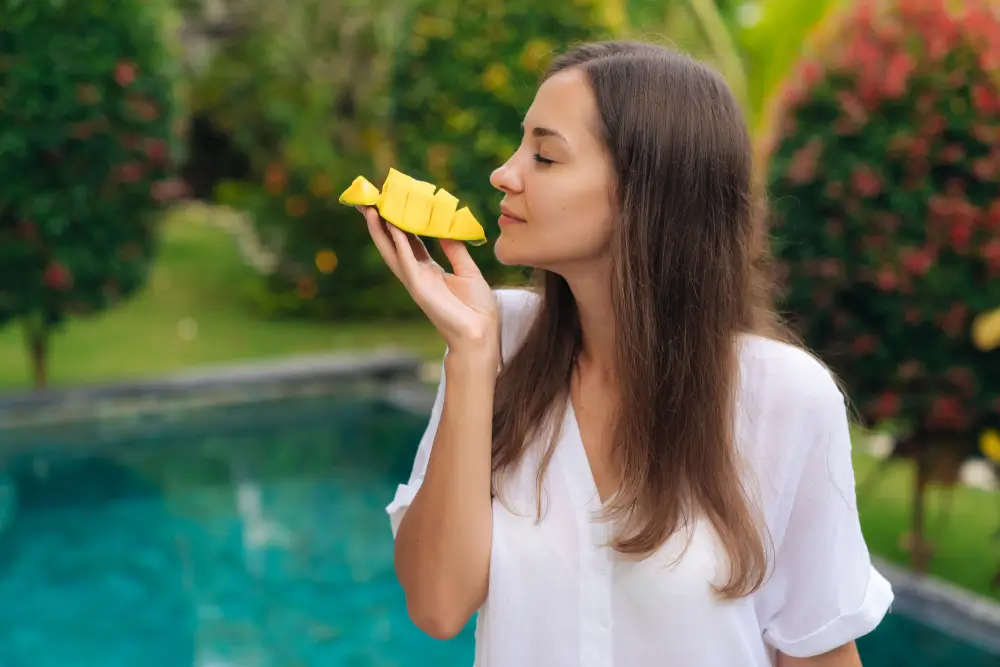shutterstock_1287575557 - Pravda24 Žena konzumuje mango.