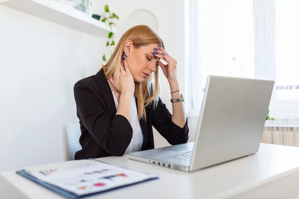 Vykonáváte-li při neschopence jinou pracovní činnost, může vám být dávka odejmuta. Zdroj: Shutterstock - Pravda24 Pracující žena, která se necítí dobře.