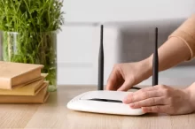Žena vypíná Wi-Fi router.