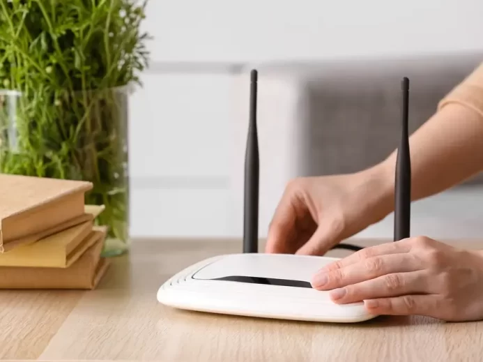 Žena vypíná Wi-Fi router.