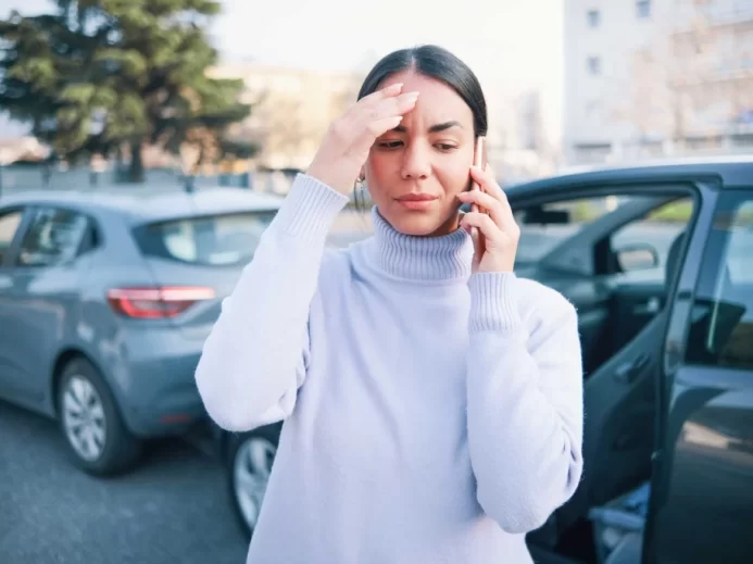 Žena telefonuje po autonehodě