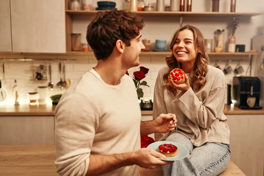 shutterstock_2409568263 - Pravda24 Muž se ženou se na sebe usmívají a konzumují sladkosti.