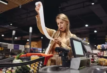 Žena udiveně se dívající na účtenku.