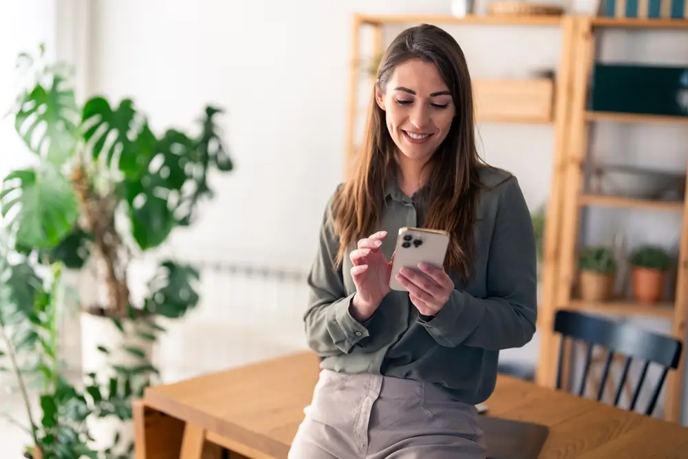 shutterstock_2469702263 - Pravda24 Žena se dívá do mobilního telefonu.