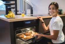 Žena, která z trouby vytahuje croissant.