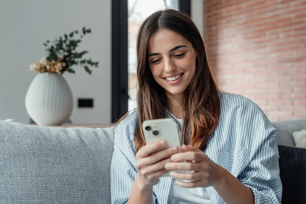 shutterstock_2473271405 - Pravda24 Žena se dívá do mobilního telefonu.