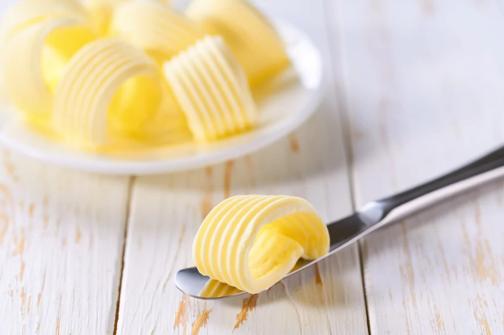 Díky přidaným látkám margarín na první pohled vypadá lákavěji. Zdroj: Shutterstock - Pravda24 Margarín připravený na noži.