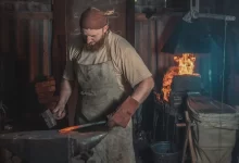 Muž kovář v dílně.