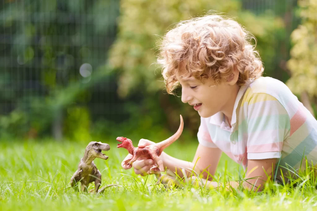 I malé děti většinou ví, že se s dinosaury nemohou setkat. Zdroj: Shutterstock - Pravda24 Chlapeček hrající si s dinosaury.
