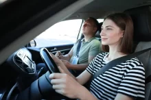 Žena v autoškole řídí auto.
