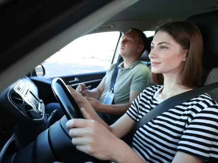 Žena v autoškole řídí auto.
