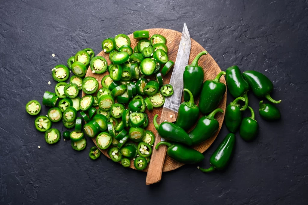 Pozor si dejte na chilli papričky i další druhy paprik. Zdroj: Shutterstock - Pravda24 Chilli papričky nakrájené na prkénku.