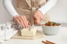 Žena krájí tofu.