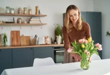 Žena dává tulipány do vázy