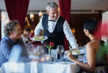 Čišník podává jídlo v restauraci