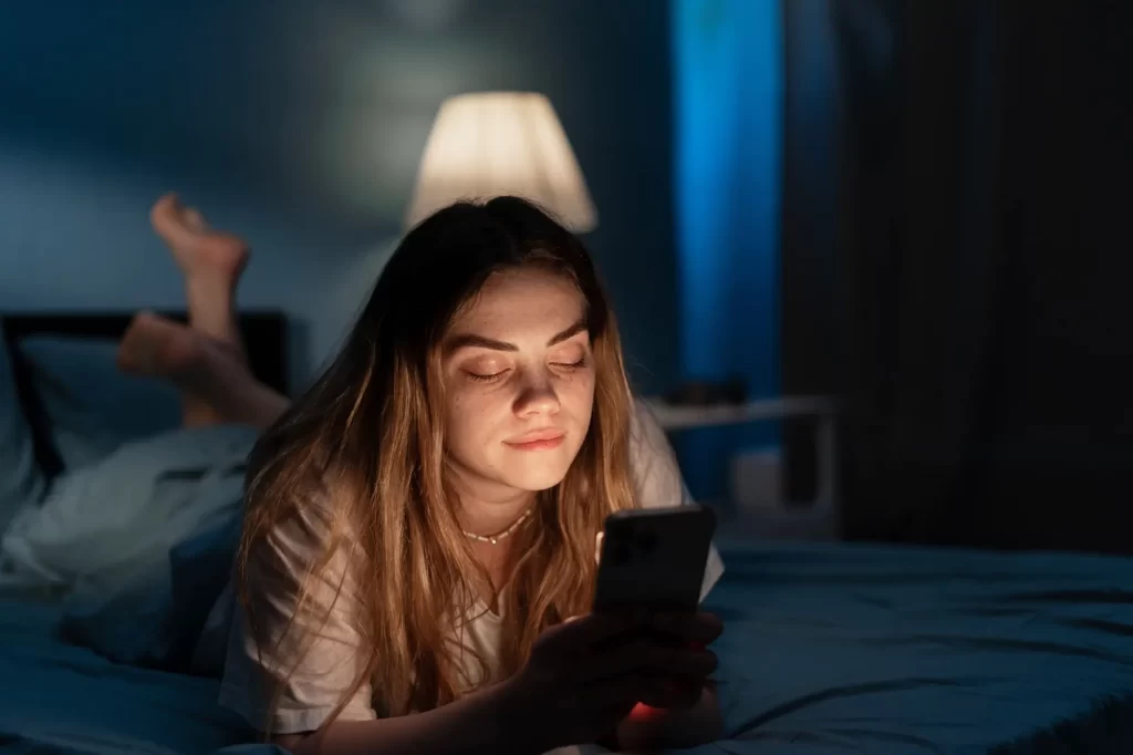 Shutterstock_2319507157 - Pravda24 Žena si prohlíží obsah na telefonu po tmě
