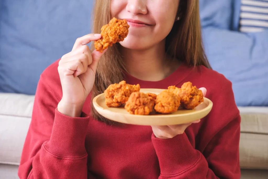 Shutterstock_2326059227 - Pravda24 Žena jí smažené jídlo