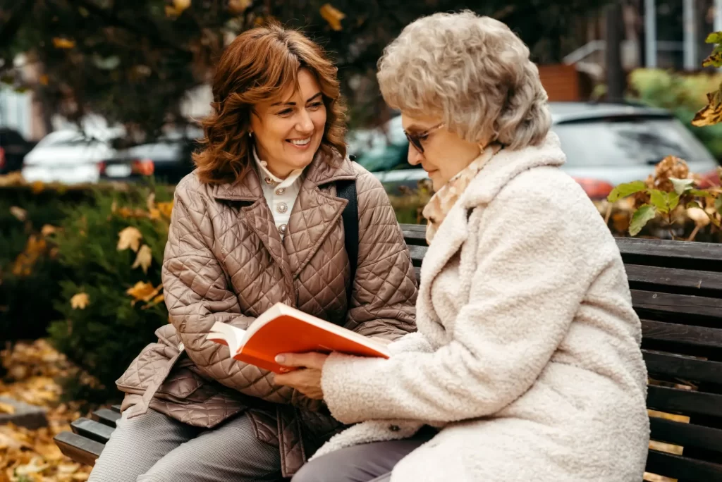 Shutterstock_2380874279 - Pravda24 Žena a seniorka na lavičce