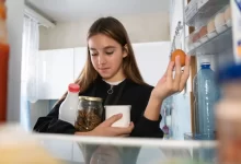 Žena beroucí potraviny z lednice