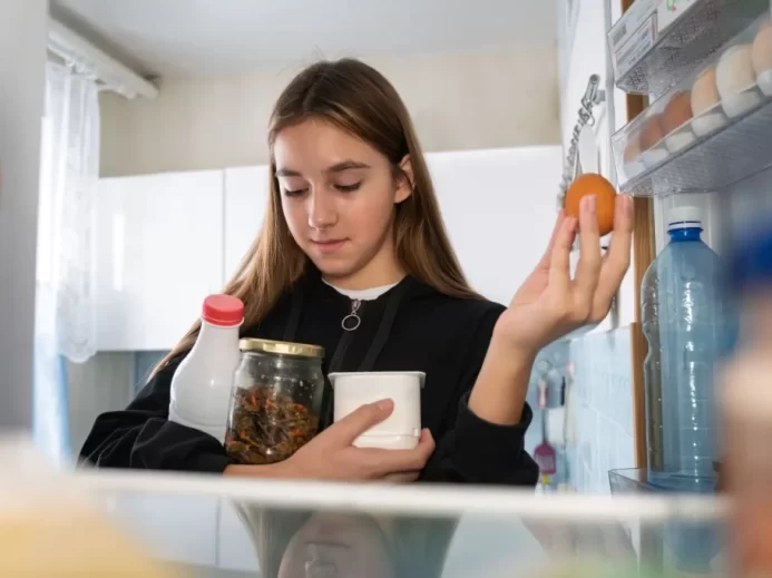 Žena beroucí potraviny z lednice