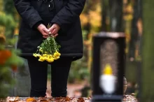 Žena se žlutými smutečními květinami.