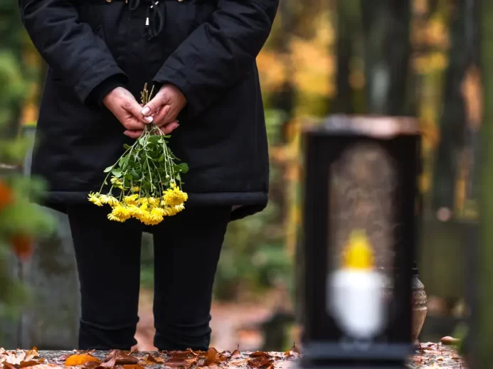 Žena se žlutými smutečními květinami.