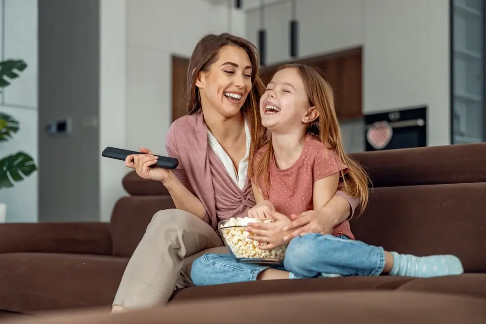 shutterstock_2194837763 - Pravda24 Žena a díte sledují televizi.