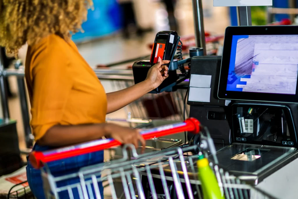 Při nákupu lidé utratí i více než 20 %. Zdroj: Shutterstock - Pravda24 Žena platící nákup u samoobslužné pokladny.