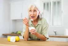 Žena konzumuje jogurt.