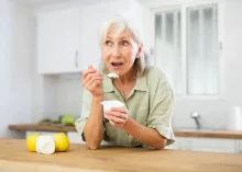 Žena konzumuje jogurt.