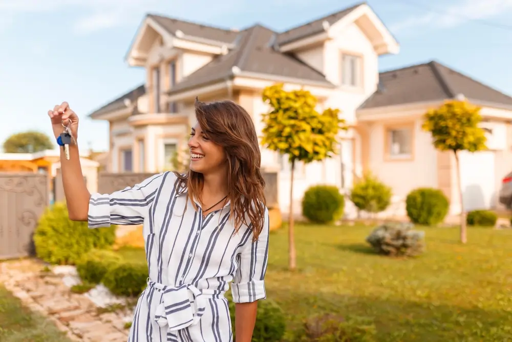 shutterstock_2337085347 - Pravda24 Žena drží v ruce klíče od auta a baráku.
