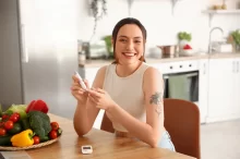 Žena si měří hladinu cukru v krvi.