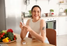 Žena si měří hladinu cukru v krvi.