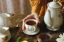 žena nalévá čaj z porcelánové konvice