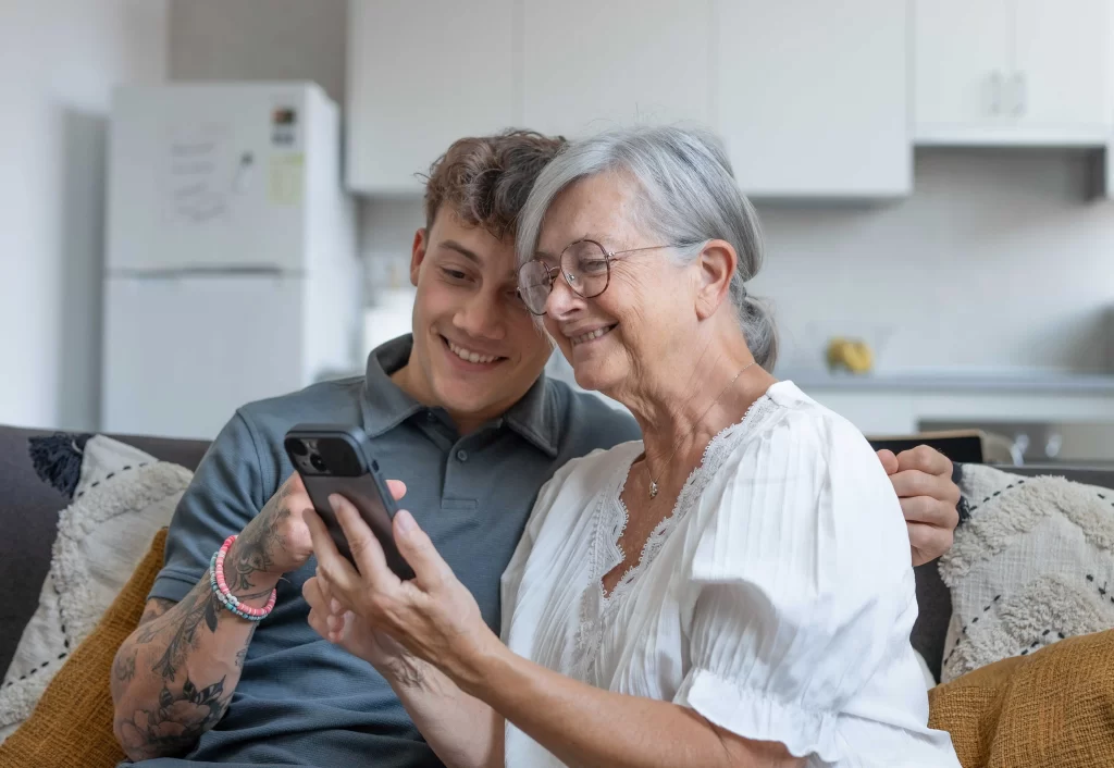 shutterstock_2460975763_optimized - Pravda24 Mladý muž se starší ženou sledují telefon