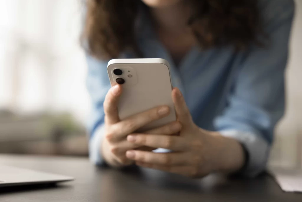 žena drží v ruce telefon